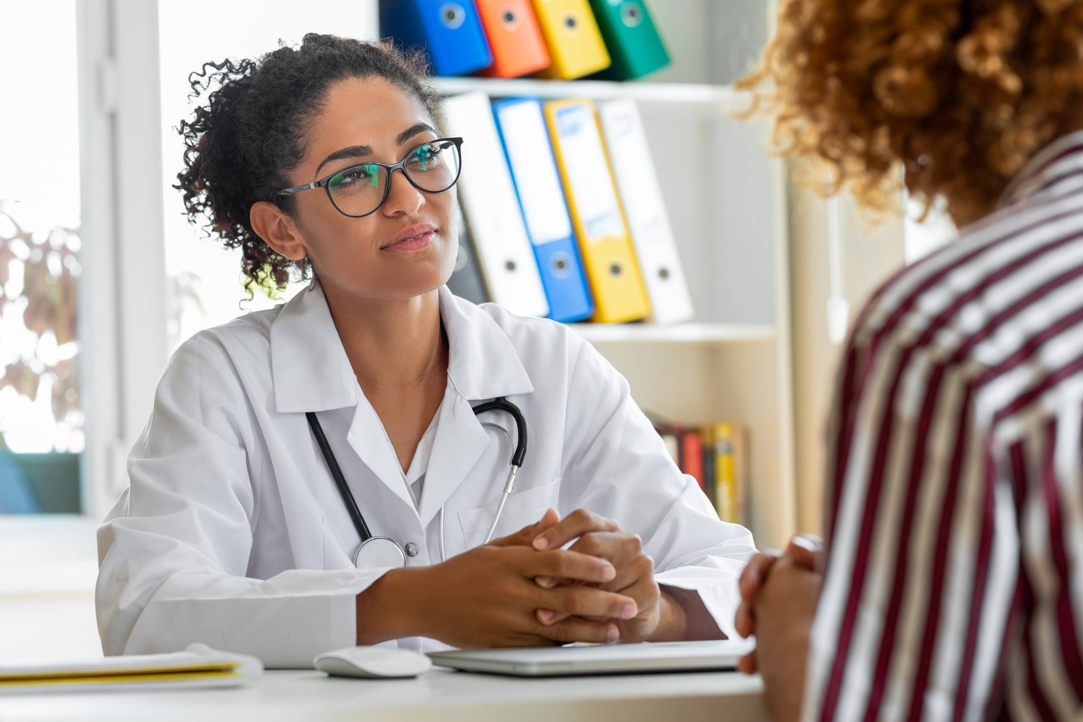 doctor sitting at desk listening to patient