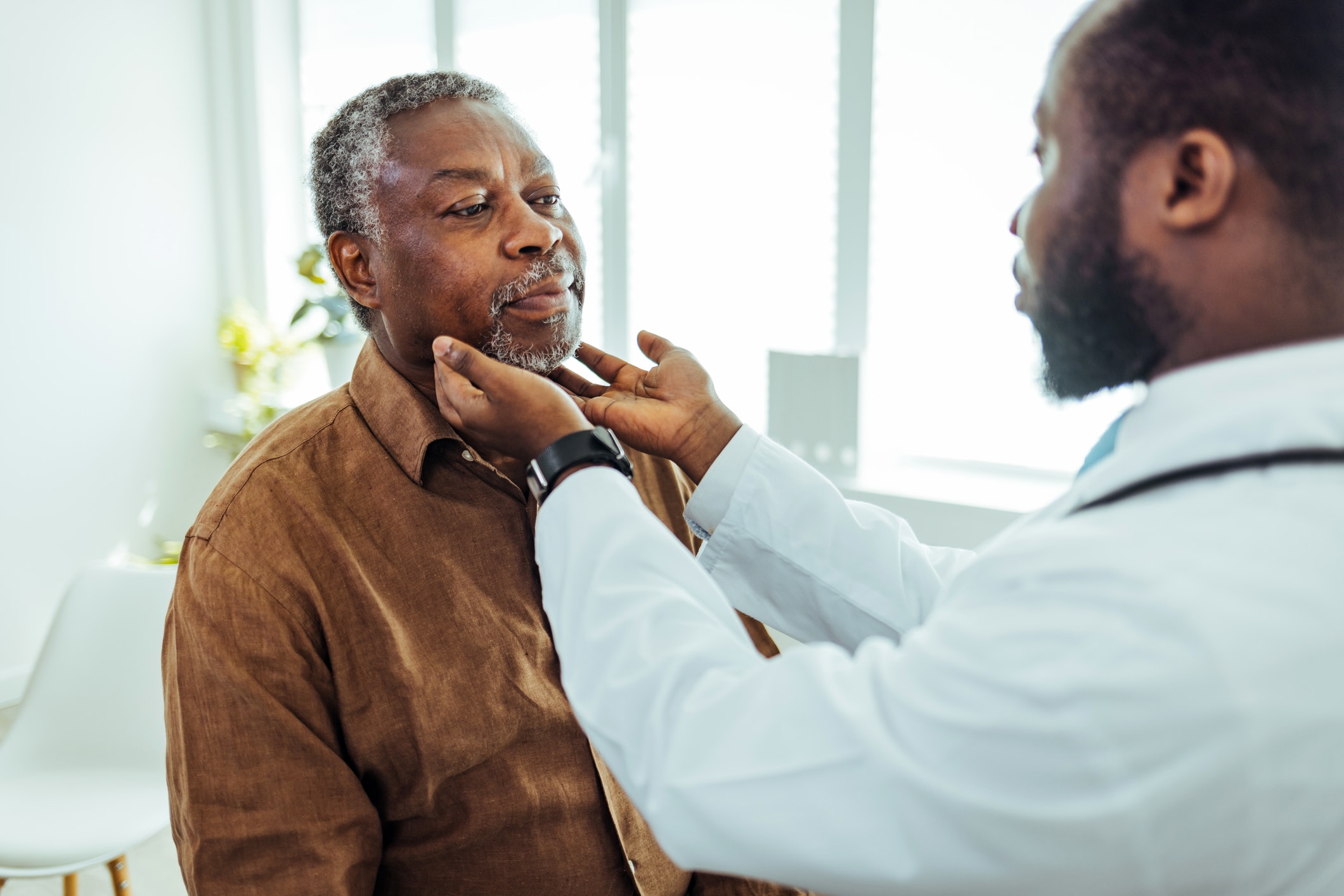 doctor feeling man's neck