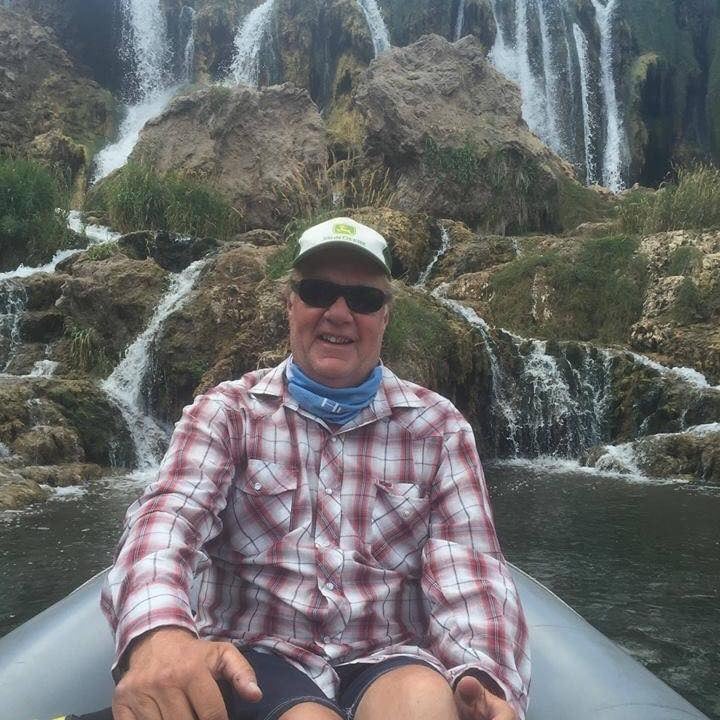 man in boat by waterfall